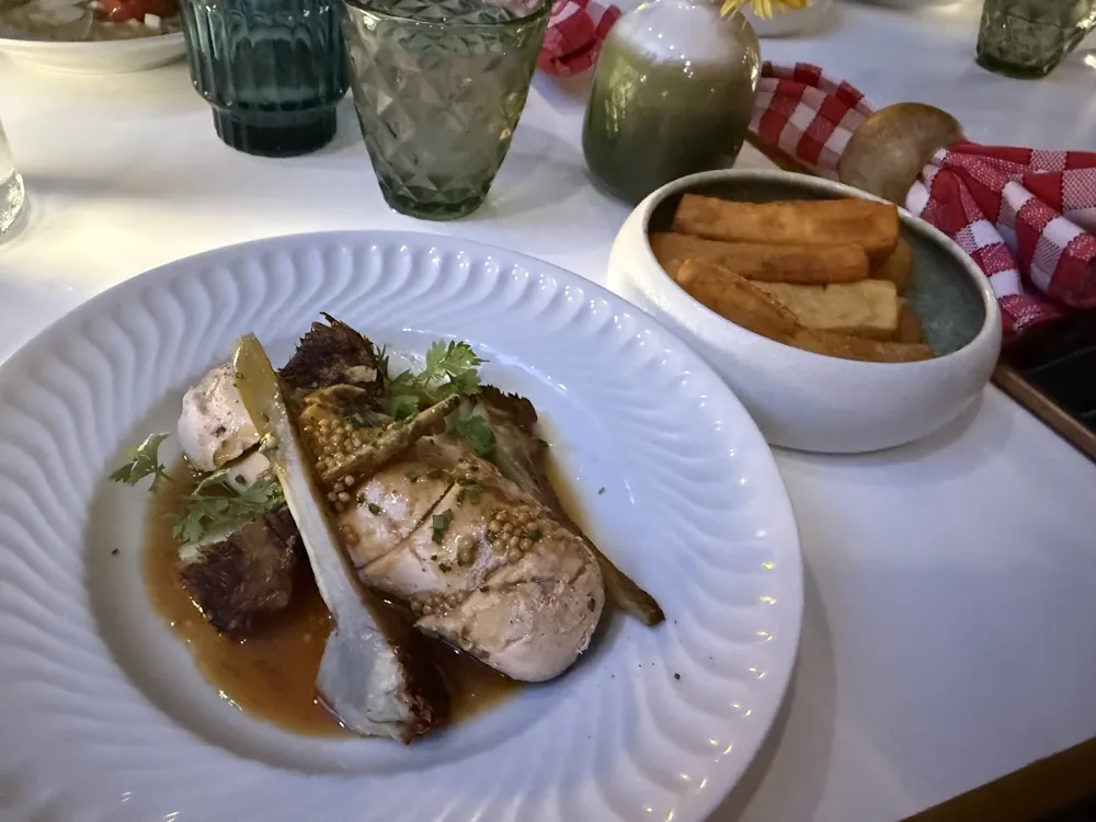 Viande rôtie tranchée dans un jus brun, avec un bol de frites à côté